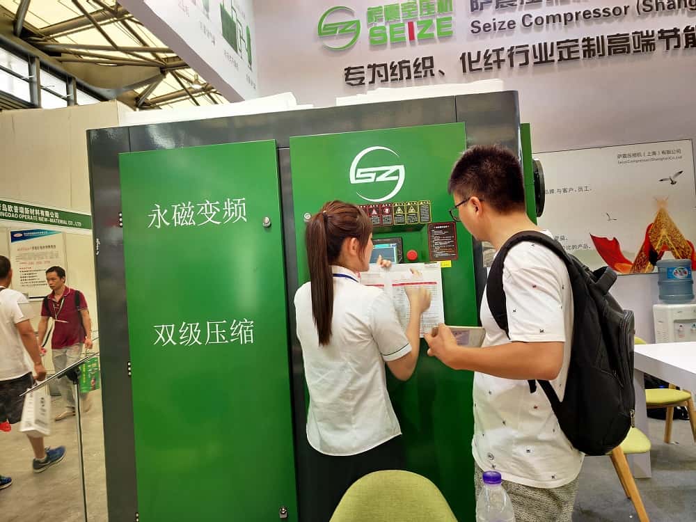 薩震美女銷售為客戶講解節(jié)能空壓機參數(shù)